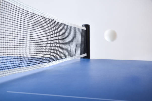 istock Ping-pong match concept with ball in motion on blue table 2144646684