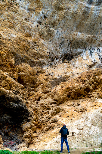 Hiker amazed by giant sandstone rock wall - Spain