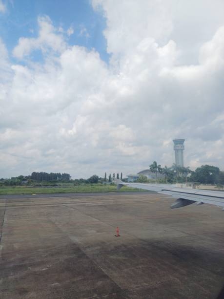 istock View from an airplane window with wing, runway and blue sky clouds. 2144725190