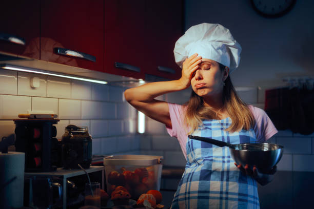 pregnant home chef trying to remember a recipe - mother emotional stress exhaustion cooking imagens e fotografias de stock