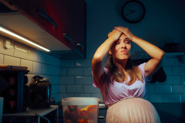 pregnant woman standing in the kitchen remembering something - mother emotional stress exhaustion cooking imagens e fotografias de stock