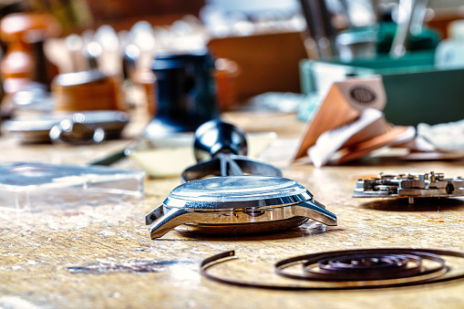 watchmaker's table: a disassembled timepiece awaits revival among tools and scattered components