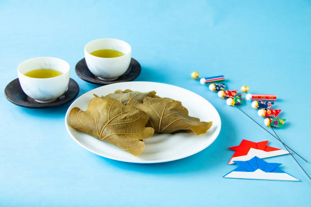 樫の葉で包んだ餅と鯉のぼりを使った日本のこどもの日。/blue の背景。