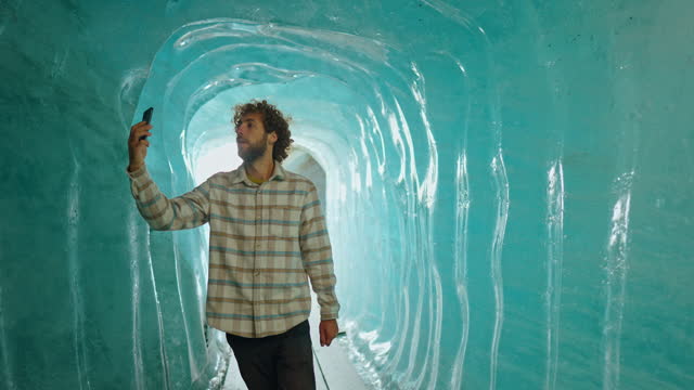 Man photographing with smartphone in ice cave
