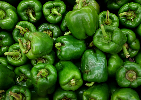 Close-up shot stack of green bell pepper at supermarket