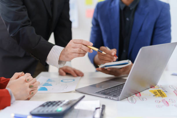 istock Business professionals collaborating using laptop and documents. Teamwork and corporate concept 2144958480