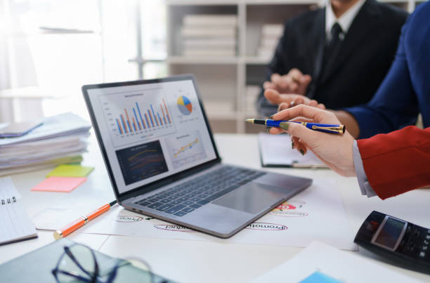 istock Business professionals collaborating using laptop and documents. Teamwork and corporate concept 2144965999