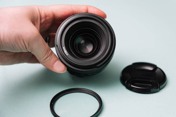 istock Hand Holding DSLR Lens with Cap and Filter 2145061061