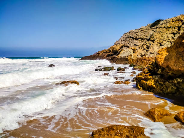 Coast of Portugal. One of the beaches in Cascais with crystal clear water. A great place for water sports - surfing.