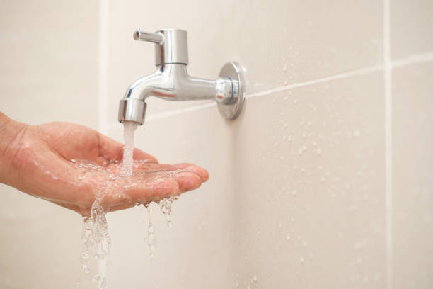 istock Male hand testing faucet strength from tap water in bathroom 2145097500