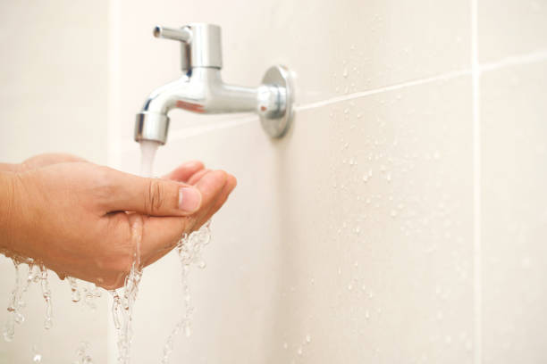 istock Male hand testing faucet strength from tap water in bathroom 2145098014