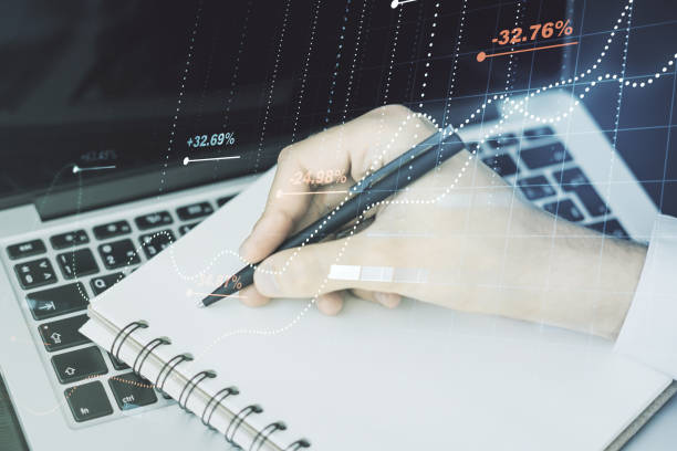 istock Multi exposure of creative statistics data hologram with hand writing in notebook on background with laptop, stats and analytics concept 2145113647