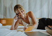 Close Up Shot of a Happy Businesswoman Working Remotely From a Hotel Room and Talking on the Phone