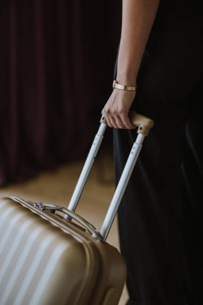 istock Close Up of an Anonymous Woman Pulling a Suitcase in a Hotel Room 2145191618