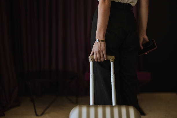 Close Up of an Anonymous Woman Pulling a Suitcase in a Hotel Room