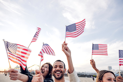A group of people holding small flags of the USA in their hands