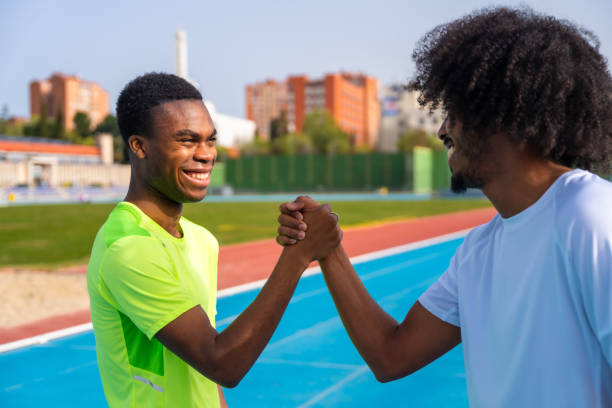 istock Runners shaking hands working out together in a running track 2145253327