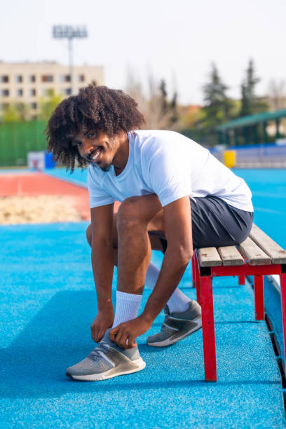 istock Smiling runner tying the shoelaces getting ready to work out 2145253833