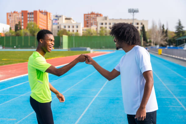 istock Runners fist bumping before training on an outdoor track 2145253847