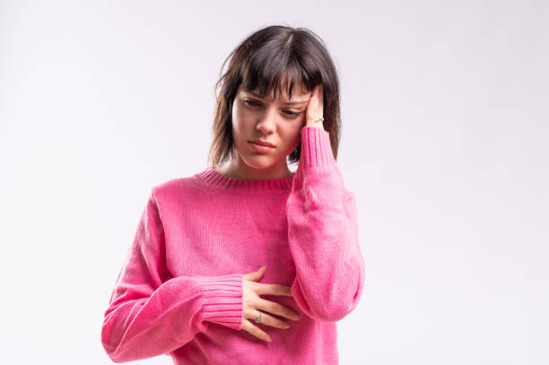 woman gesturing discomfort and headache - women guilt uncomfortable human face imagens e fotografias de stock