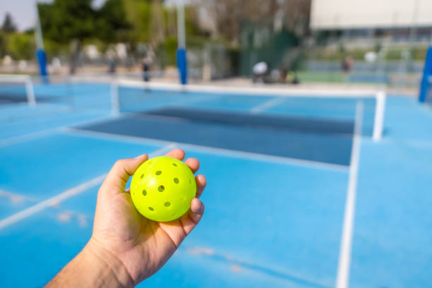 istock Unrecognizable person holding a plastic yellow pickleball ball 2145260787