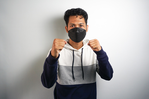 Asian man wear hygienic mask and post Boxing guard action for fight the disease