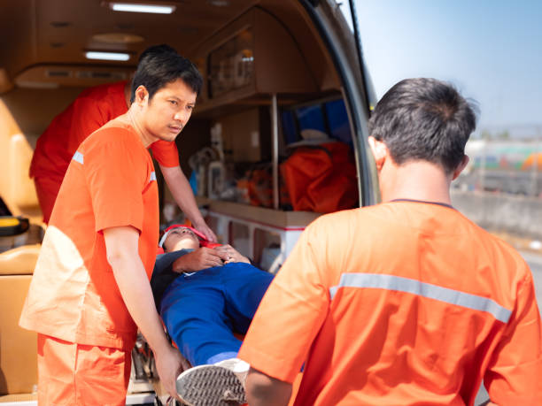 istock Paramedic in uniform  loading patient on stretcher into ambulanceworking together with team 2145312630