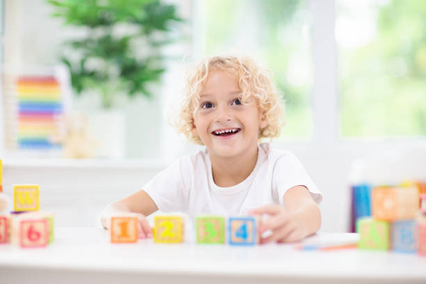 istock Child learning letters. Kid with wooden abc blocks 2145380041