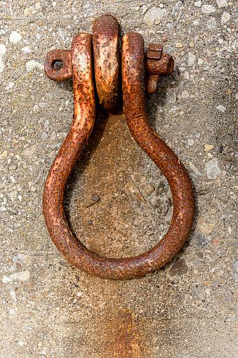 Old rusty mooring ring on a pier wall concrete, weathered och well used