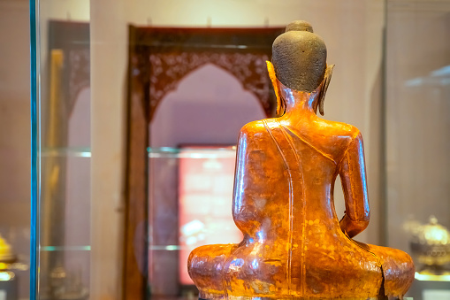 Bangkok, Thailand - November 11 2019: An ancient Buddha statue displayed in a hall at the Bangkok National Museum