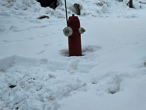 A fire hydrant that is surrounded by snow.