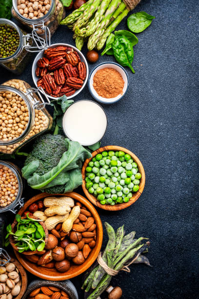 istock Vegan food background with empty space. Plant protein., vegetarian nutrition sources. Healthy eating, diet ingredients: legumes, beans, lentils, nuts, soy milk, tofu, cereals, seeds and sprouts. Top view, black table 2145534802