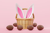 Basket with Easter bunny ears and chocolate eggs