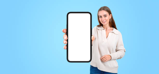 istock Young woman showing phone with blank screen 2145537863