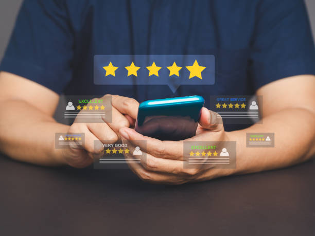 istock Customer reviews concept. Young man using a smartphone with rating icons on the screen. 2145556521