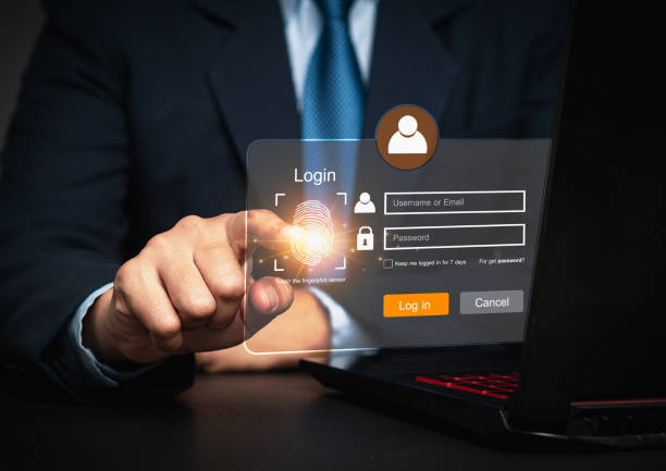 istock Businessman hand touches a fingerprint sensor on a laptop, with a login interface displayed on the virtual screen. 2145556526