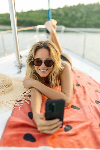 istock A beautiful young woman lying on a sailboat deck while sailing 2145583778