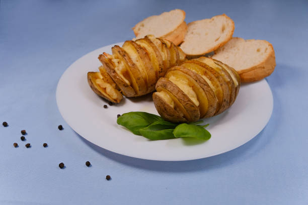 Baked potatoes with lard on a plate. Dish on a white plate with basil added.