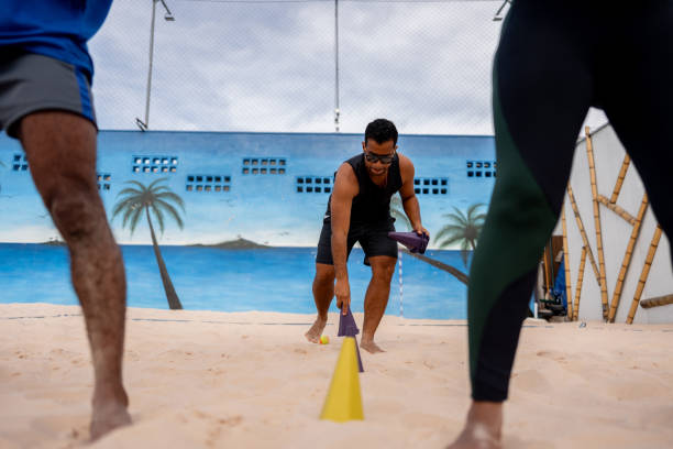 istock Young man putting cones on sand on a tennis beach venue 2145688772