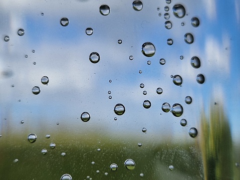 Raindrops on the glass of the car against the evening sky