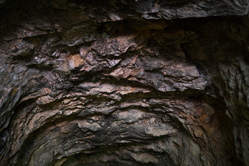 Close-up of the rugged rock wall lining an underground tunnel