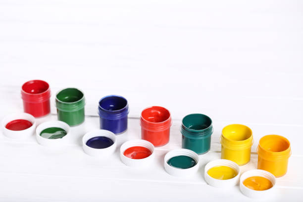 Colorful gouache paints on white wooden table