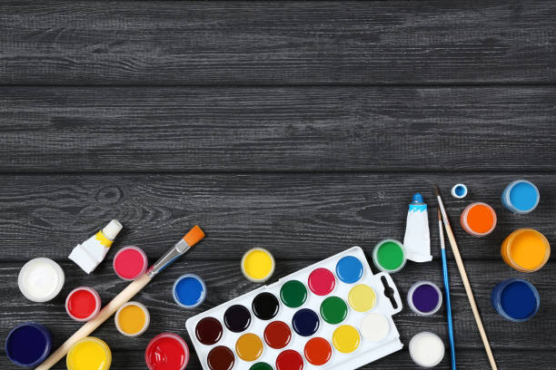 istock Colorful gouache paints and brushes on black wooden table 2145750713