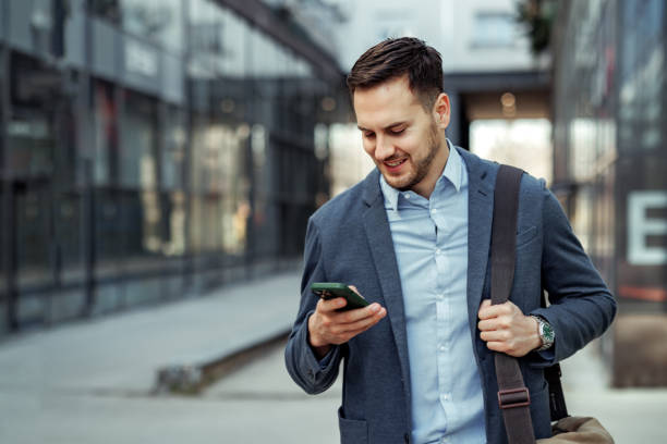 istock Well dressed handsome businessman using phone while walking in the city 2145790229