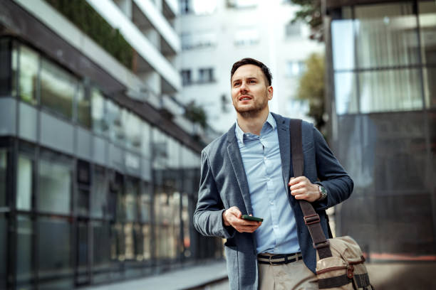 istock Well dressed handsome businessman using phone while walking in the city 2145790308