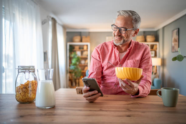 istock A mature man prepares breakfast with cornflakes 2145801660