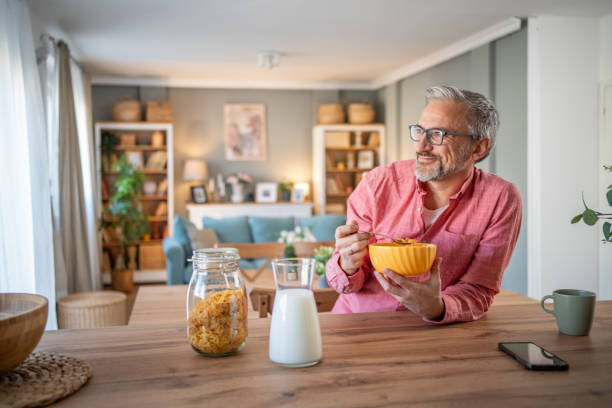 istock A mature man prepares breakfast with cornflakes 2145802563