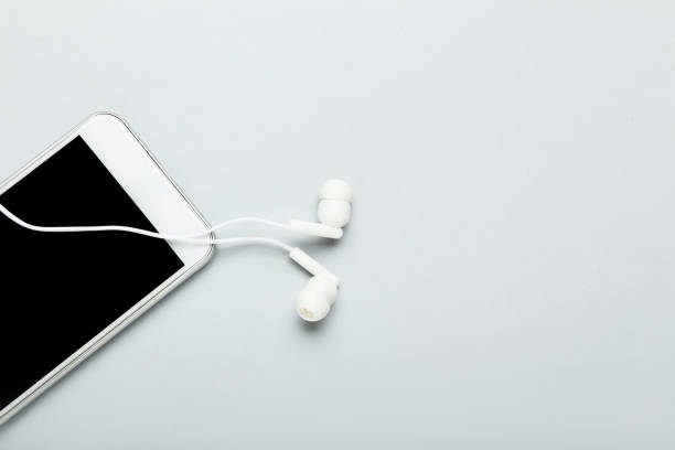 istock Earphones with mobile phone on grey background 2145818521