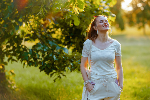 Summer time. smiling elegant woman in white shirt enjoying outside in nature.
