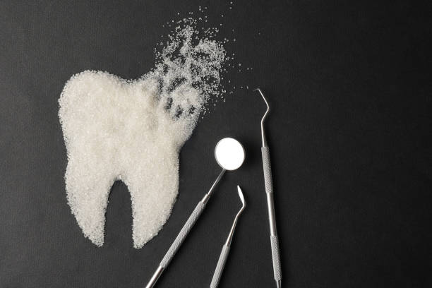 istock Dentist tools mirror and teeth made of sugar on a black background 2145850937